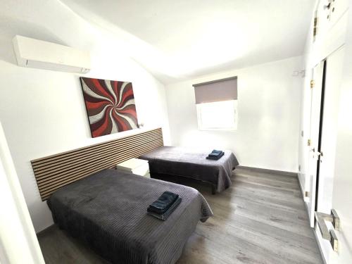 een kleine kamer met 2 bedden en een raam bij Villa Sunshine - Albufeira in Albufeira