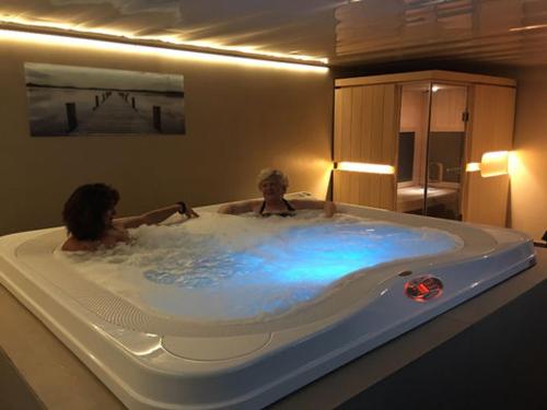 two people in a bath tub in a room at Le Bois Saint Martin in Saint-Martin-de-Ré