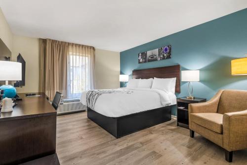 a hotel room with a bed and a desk and a chair at Sleep Inn & Suites in Newport News