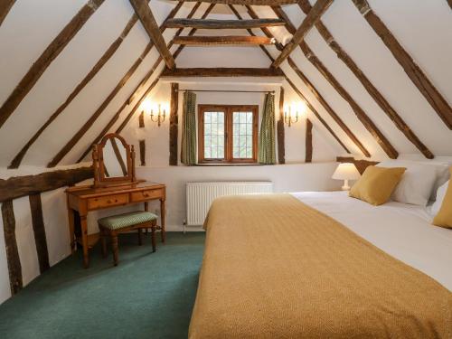 a bedroom with a bed and a desk in a attic at Bluebell in Woodbridge