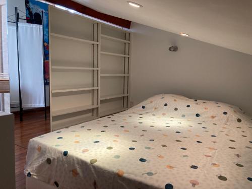 - un lit avec des draps en polka dans une chambre dans l'établissement Duplex de la République, à Millau