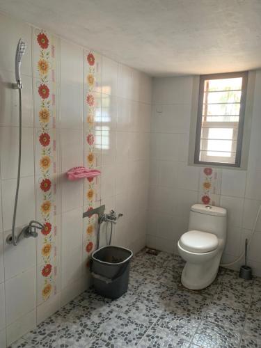 a bathroom with a toilet and a bucket at Casa Ganesha beach residence in Irimbranallūr