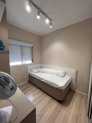 een kleine slaapkamer met een bed en een raam bij Apartamento novo e aconchegante! in Mogi-Mirim