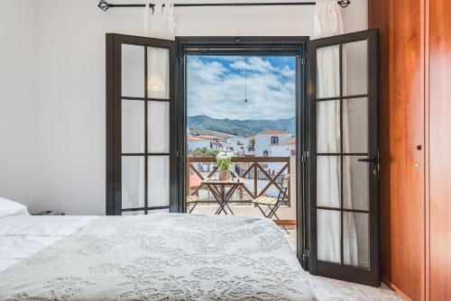 1 dormitorio con puerta abierta a un balcón en Home2Book Charming House Agaete, BBQ & Garden, en Agaete