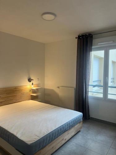 une chambre avec un grand lit avec une fenêtre dans l'établissement Le Vienna, à Juvignac