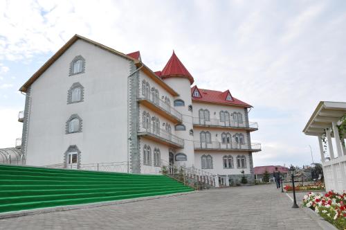 ein großes weißes Gebäude mit rotem Dach in der Unterkunft Altyn Kun Hotel in Borovoye