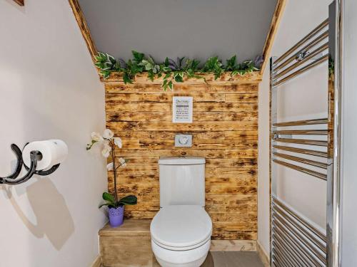 a bathroom with a toilet with a wooden wall at 1 Bed in Christchurch 54900 in Ringwood