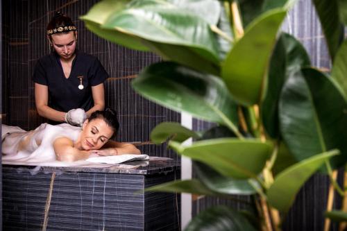 a man giving a woman a bath in a bath tub at Amsterdam Plaza Hotel & SPA in Palanga