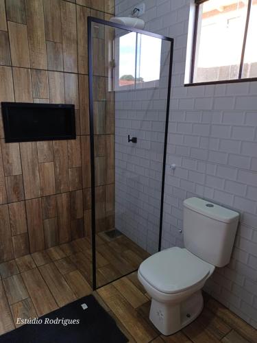 uma casa de banho com um WC e um chuveiro em Apê Estúdio Tropical em Paranaíba