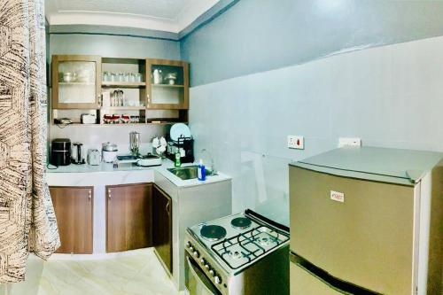 Il comprend une petite cuisine équipée d'une cuisinière et d'un évier. dans l'établissement StarHomes, Jinja, à Jinja