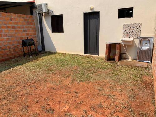 a yard with grass and a building and a grill at Hermosa casa, zona Aeropuerto in Luque