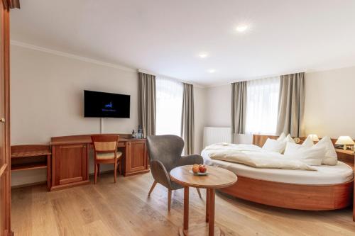 a hotel room with a large bed and a table at Hotel Weisser Hirsch in St. Wolfgang