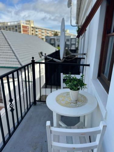 una mesa en un balcón con una planta en Affordable Guest house in Mwobray, en Ciudad del Cabo