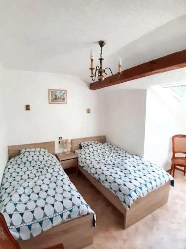 - une chambre avec 2 lits, une table et un lustre dans l'établissement Maison enchanteresse à Ingersheim avec vue sur la montagne, à Ingersheim