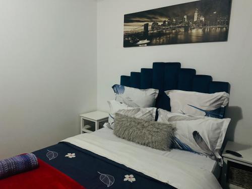 1 cama con cabecero azul y almohadas blancas en Affordable Guest house in Mwobray, en Ciudad del Cabo