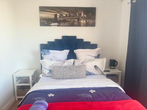 1 cama con cabecero azul en un dormitorio en Affordable Guest house in Mwobray, en Ciudad del Cabo