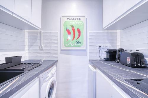 - une cuisine blanche avec un lave-linge et un panneau dans l'établissement Apartment 3 People Voltaire-Saint Ambroise, à Paris