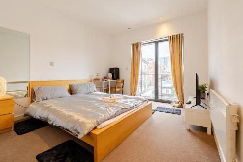 a bedroom with a bed and a large window at Private Ensuite Room with Balcony at the Heart of Cardiff in Cardiff