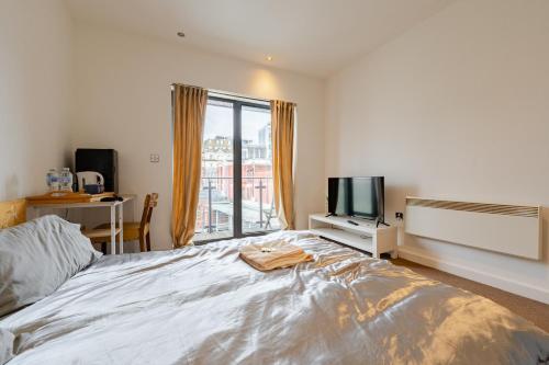 a bedroom with a large bed and a television at Private Ensuite Room with Balcony at the Heart of Cardiff in Cardiff