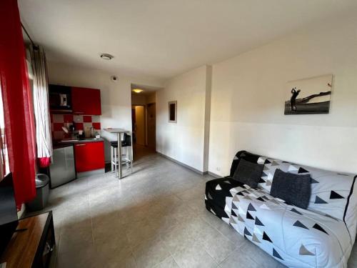 un salon avec un canapé et une cuisine dans l'établissement Le Sacramento, à Juvignac