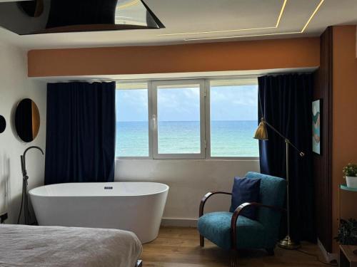 a bedroom with a tub and a window with the ocean at Villa Marbella by Potenza Rentals in Santo Domingo
