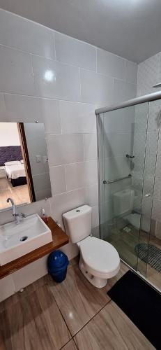 a bathroom with a toilet and a sink and a shower at Pousada Felix in São Gabriel