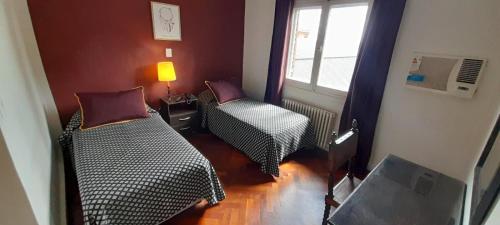 a room with two beds and a tv and a window at Hotel Dos Venados in San Luis