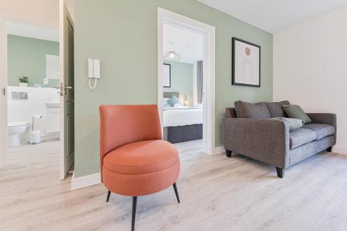 a living room with a chair and a couch at Stylish 2 Bed Apartment Nightingale Quarter Derby in Derby