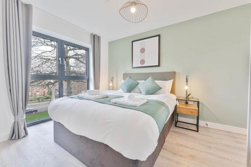 a bedroom with a large bed and a window at Stylish 2 Bed Apartment Nightingale Quarter Derby in Derby