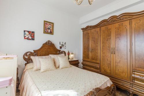 a bedroom with a wooden bed and a large wooden cabinet at Casa Venta Ruizo in Lorca