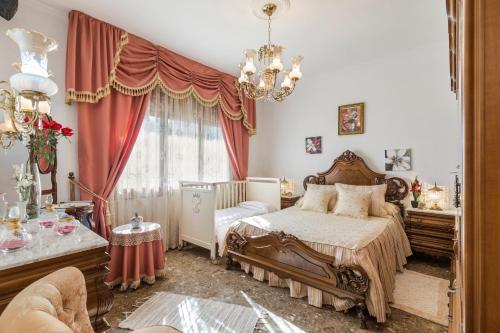 1 dormitorio con cama y lámpara de araña en Casa Venta Ruizo, en Lorca