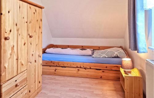 a bedroom with a large wooden bed with blue sheets at Cozy Apartment In Blankensee With Kitchen in Blankensee