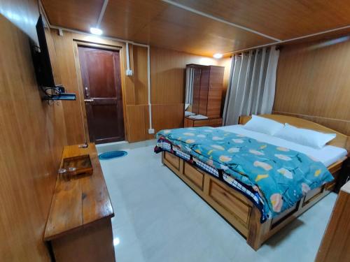 un dormitorio de un barco con una cama en él en Gyatso Guest House en Tawang