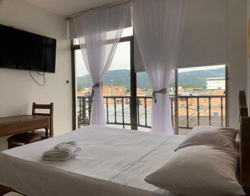 1 dormitorio con cama y ventana grande en HOTEL EJECUTIVO, en Pitalito