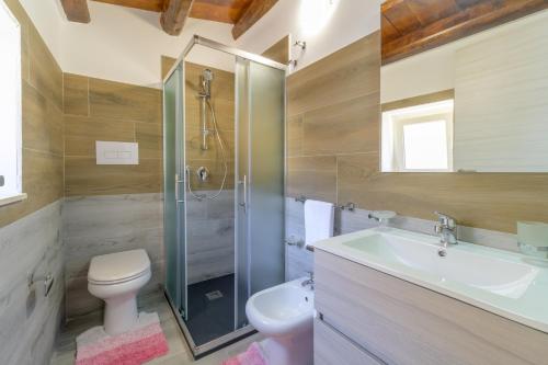 y baño con aseo, lavabo y ducha. en Villa Arjana, en Camemi