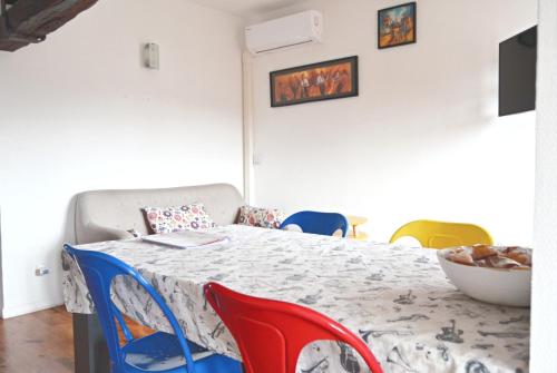a dining room with a table and colorful chairs at Je jazz les couleurs à Albi - Centre Unesco - Parking - Climatisation - Animaux acceptés in Albi