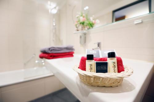 a bathroom counter with a basket of products on it at Hotel Franz in Essen