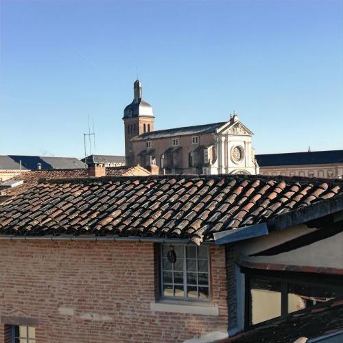 an old brick building with a clock tower in the background at Je jazz les couleurs à Albi - Centre Unesco - Parking - Climatisation - Animaux acceptés in Albi