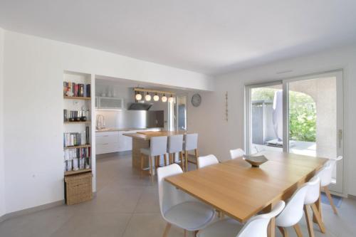 uma cozinha e sala de jantar com uma mesa de madeira e cadeiras em Pretty terraced house with garden level and garage em Aix-les-Bains