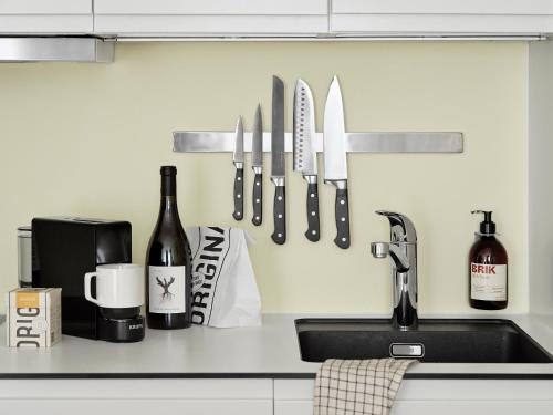 a kitchen counter with a sink and a knife rack at BRIK Apartment Hotel in Copenhagen