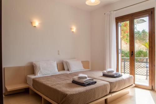 1 dormitorio con 1 cama grande y toallas. en Agnanti Marina villa with private pool, en Skouloúfia