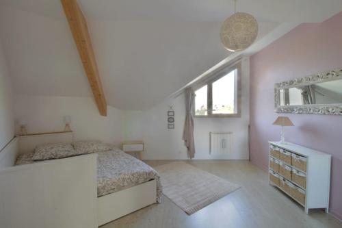 a bedroom with a bed and a dresser and a window at Pretty terraced house with garden level and garage in Aix-les-Bains