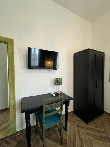 a desk with a chair and a tv on a wall at Umi B&B in Giulianova
