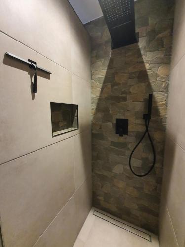 a bathroom with a shower with a stone wall at Bij ons op de Hoep. in Schagen