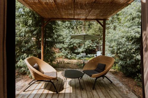 a patio with a table and chairs and an umbrella at Le Bois Saint Martin in Saint-Martin-de-Ré