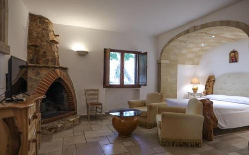 een hotelkamer met een bed en een open haard bij Tenute Al Bano in Cellino San Marco