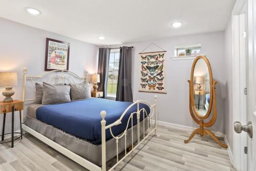 1 dormitorio con cama azul y espejo en Skip to Saint Charles Local Art-Filled Hideaway, en Nueva Orleans