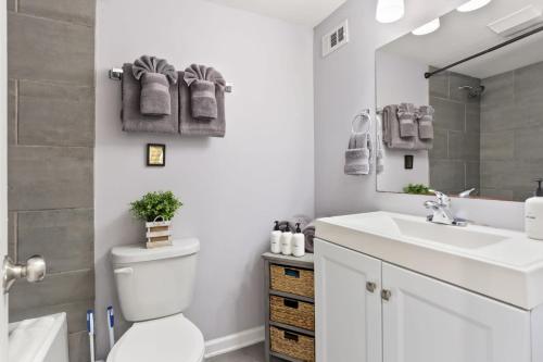 a bathroom with a toilet and a sink and a mirror at Skip to Saint Charles Local Art-Filled Hideaway in New Orleans