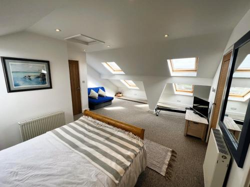 ein Schlafzimmer mit einem Bett in einem Zimmer mit Oberlichtern in der Unterkunft North Quay in Saint Helens