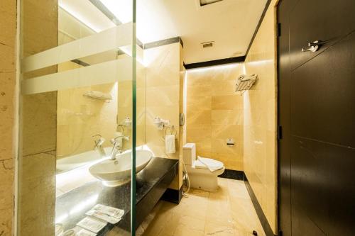 a bathroom with a sink and a toilet at Grand Jatra Hotel Pekanbaru in Pekanbaru
